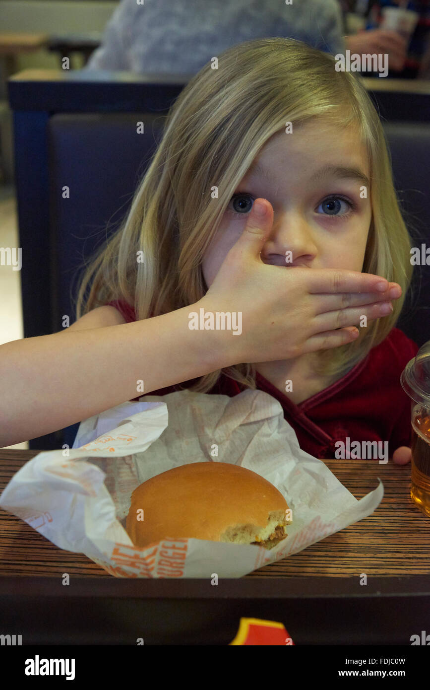 Adorable girl have meal in fast food restaurant Stock Photo