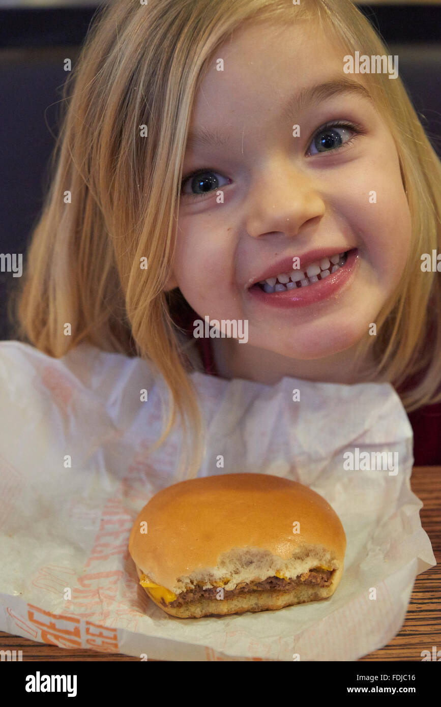 Adorable girl have meal in fast food restaurant Stock Photo