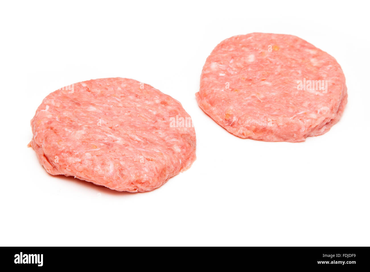Raw crocodile meat burgers isolated on a white studio background. Stock Photo
