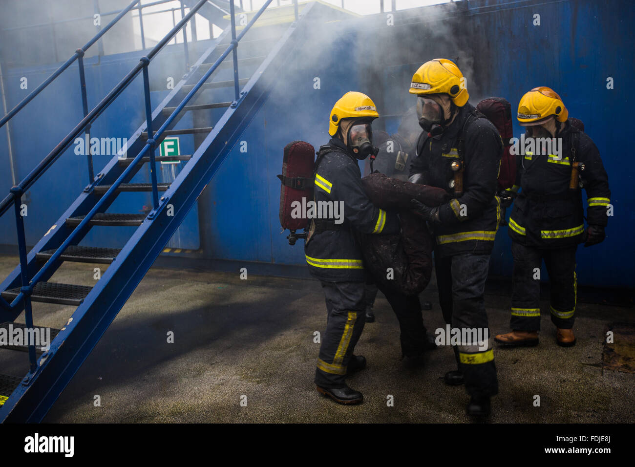 Seafarers and offshore workers retrieve a casualty during firefighting training Stock Photo
