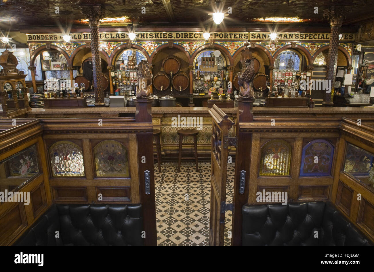View from one of the wooden snugs towards the bar at The Crown Bar, Great Victoria Street, Belfast. Formerly known as the Crown Liquor Saloon, the pub building dates from 1826 but the wonderful late Victorian craftsmanship of the tiling, glass and woodwor Stock Photo