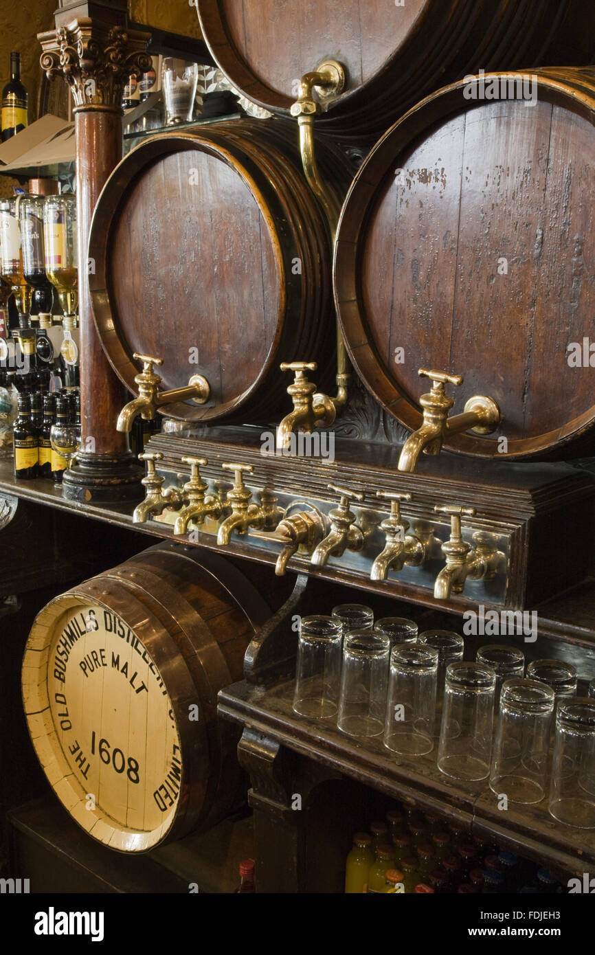 Wooden beer barrels and taps at The Crown Bar, Great Victoria Street, Belfast. Formerly known as the Crown Liquor Saloon, the pub building dates from 1826 but the wonderful late Victorian craftsmanship of the tiling, glass and woodwork undertaken by Itali Stock Photo