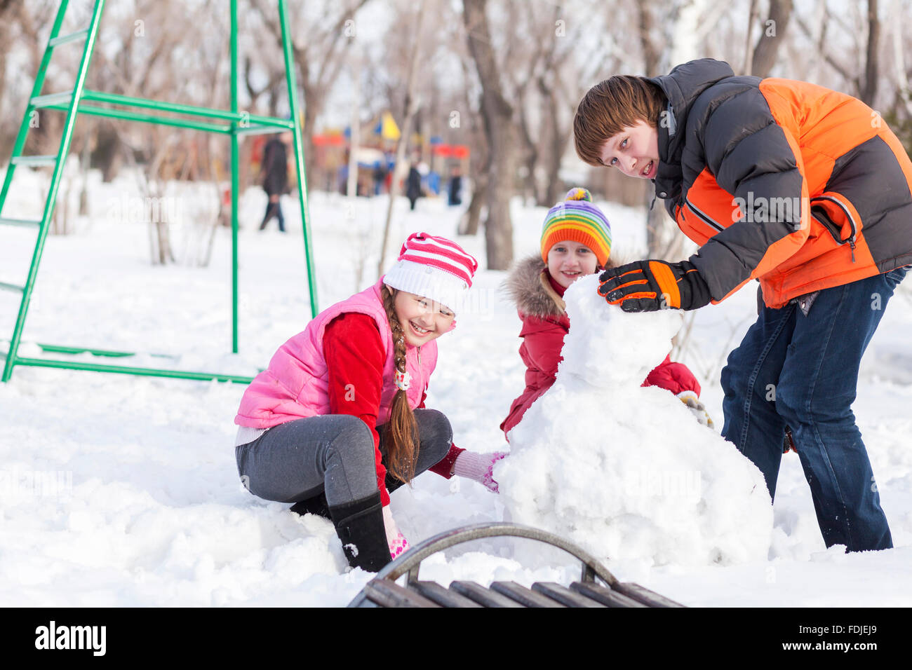 Children in winter park having fun and playing snowballs Stock Photo ...