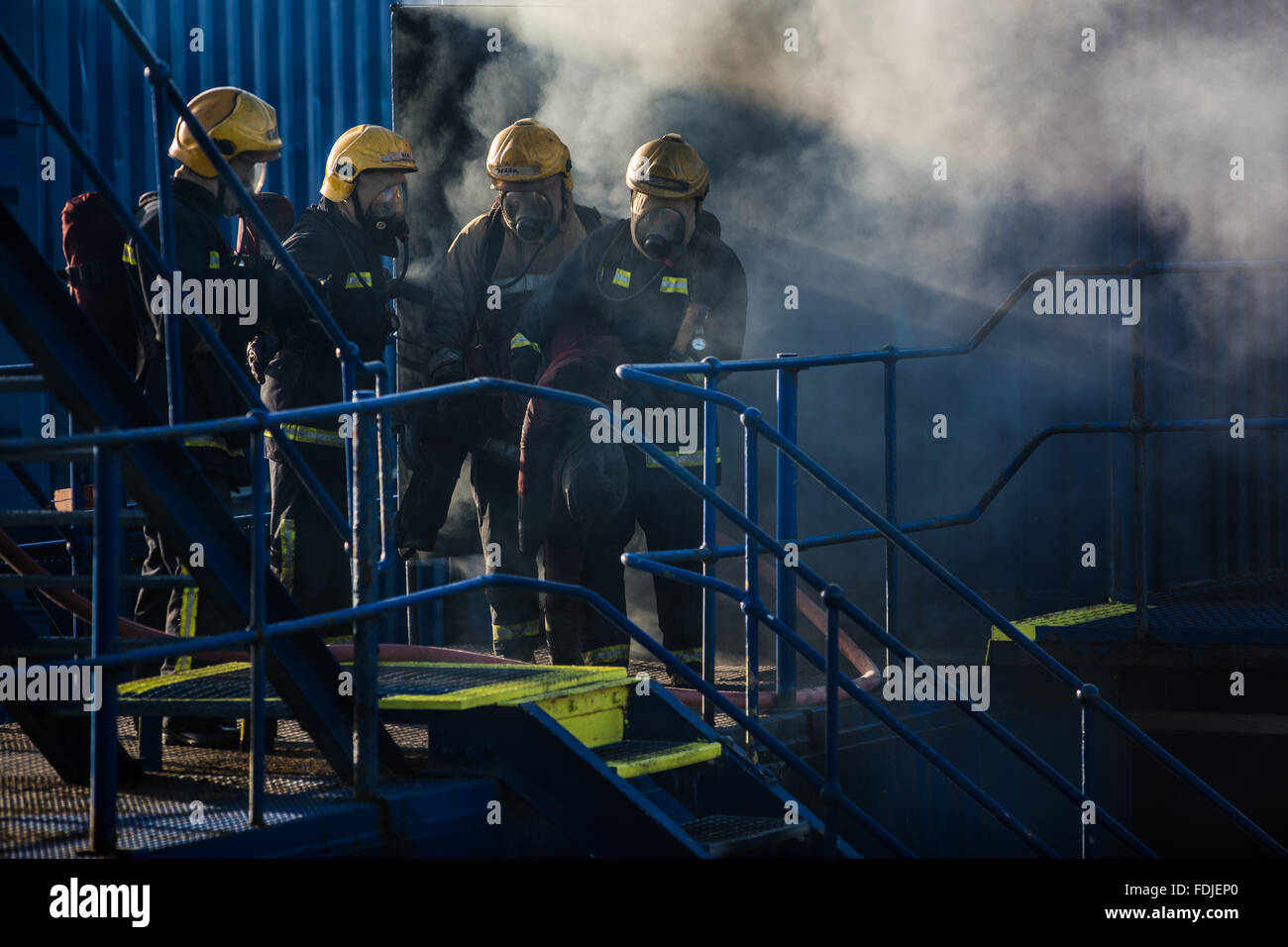 Seafarers and offshore workers retrieve a simulated casualty during firefighting training Stock Photo