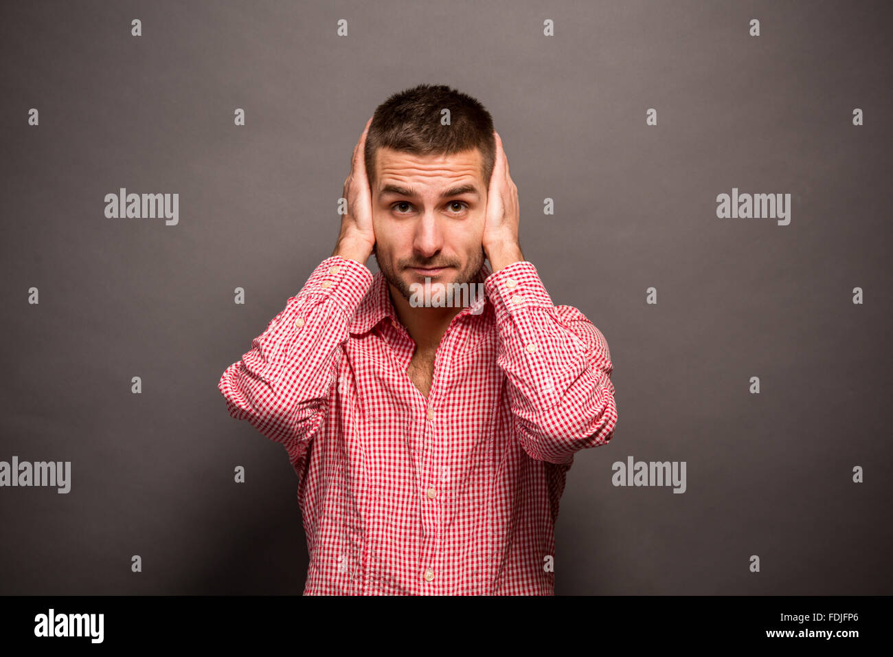 Man covering his ears Stock Photo