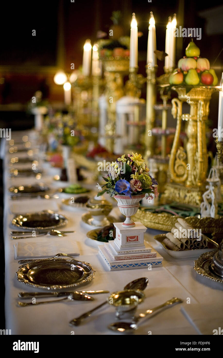 Dining table and candelabra with floral arrangements and tableware in