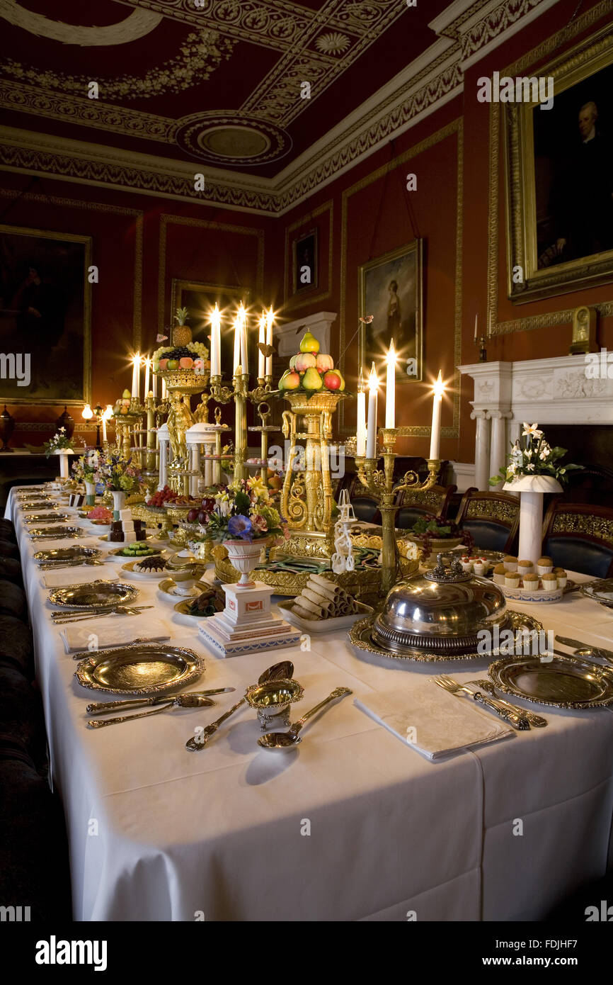 The Dining Room at Attingham Park, Shrewsbury, Shropshire, with the dining table laid for a formal dinner and with table decorations and candelabra. Stock Photo