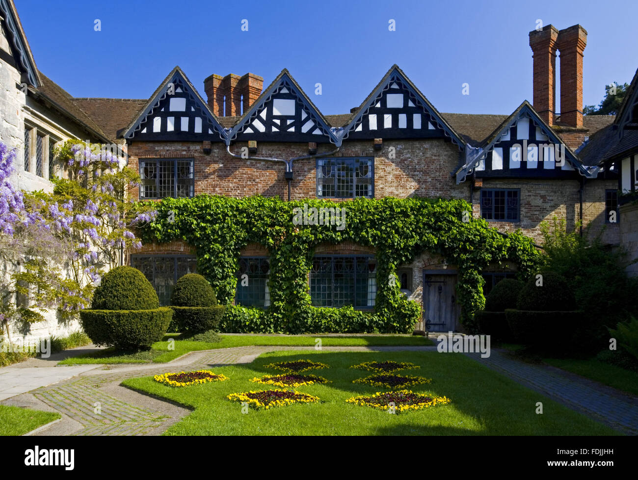 The Courtyard at Baddesley Clinton, Warwickshire. The Courtyard garden was created in 1889 by Edward Heneage Dering with the lozenges of the Ferrers family coat of arms laid out on the lawn as flowerbeds.. Stock Photo
