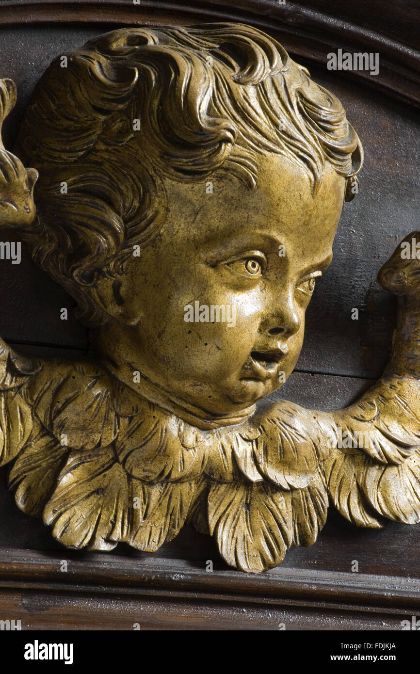 Close view of a carved wooden face of an angel on the seventeenth-century woodwork in the Chapel at Petworth House, West Sussex. Stock Photo
