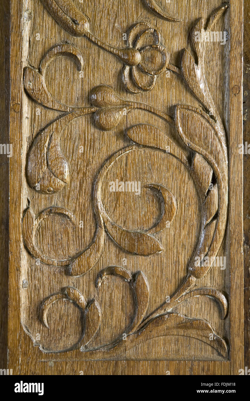 Close view of carved wooden panel with a floral motif on the door frame leading to the Entrance Hall from the Great Hall at Baddesley Clinton, West Midlands. Stock Photo