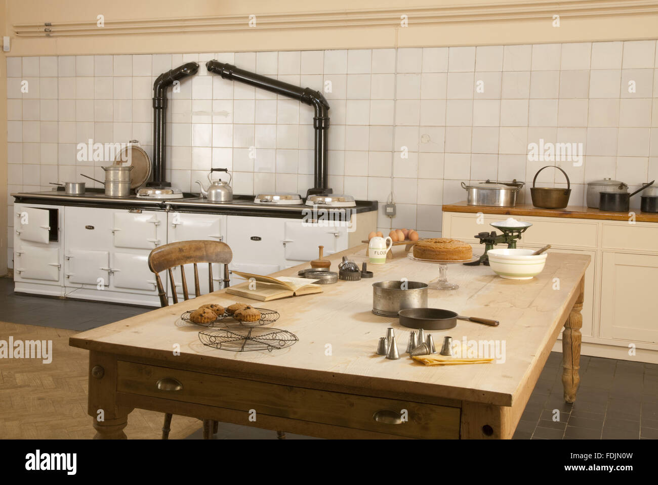 The Kitchen at Upton House, Warwickshire. The Aga is in the background, with the kitchen table in the foreground. The cakes on the table have been made to an original 1930s recipe. Stock Photo
