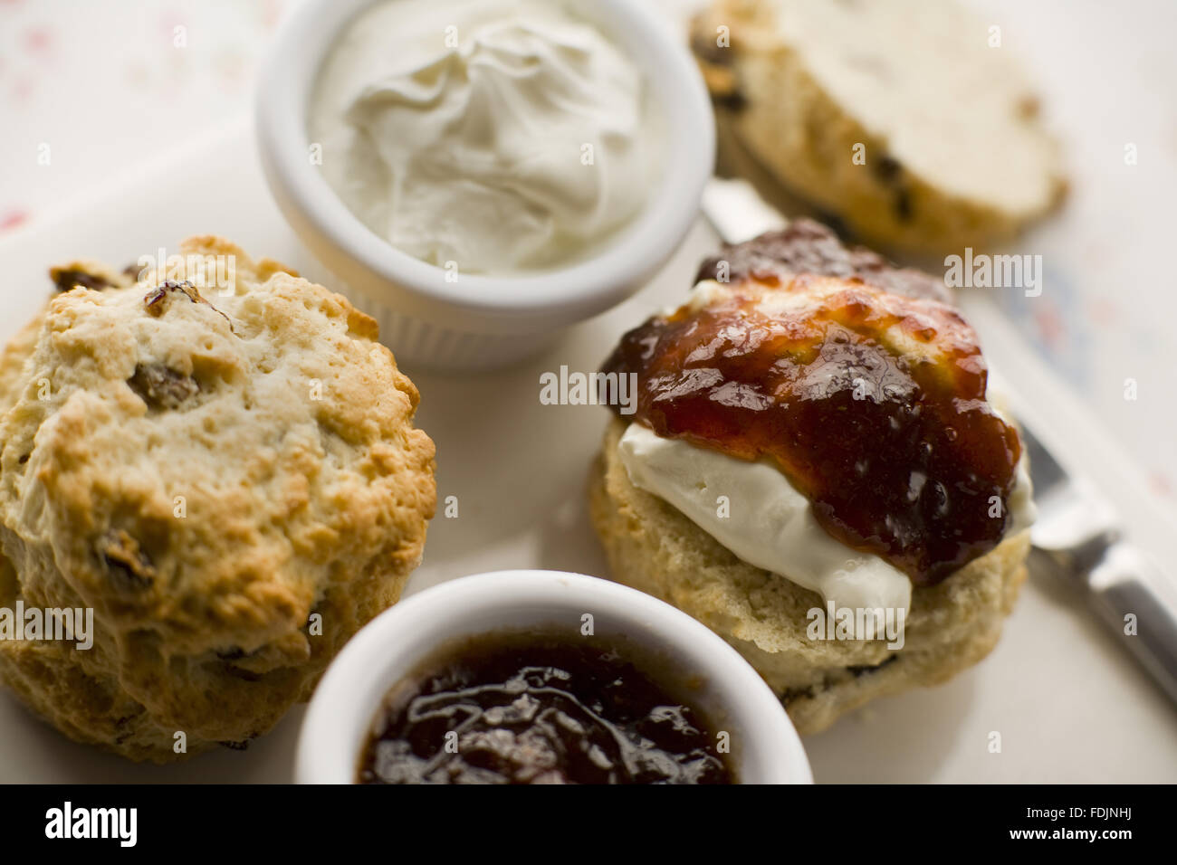 Afternoon tea with fruit scones, clotted cream and jam in the restaurant at Sissinghurst Castle Garden, Kent. Stock Photo