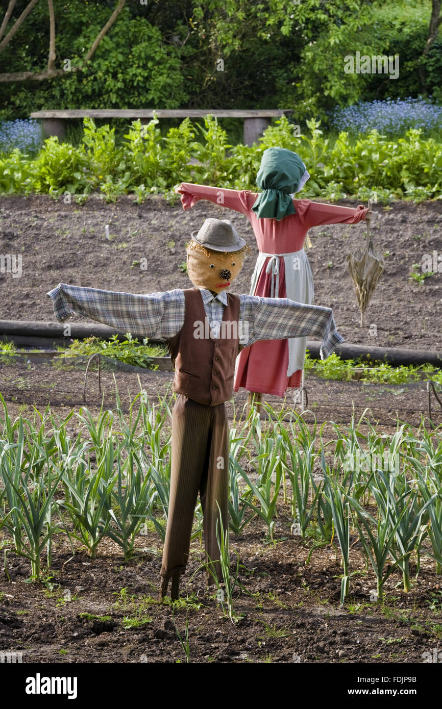 Scarecrows in the Apprentice House garden in May which is part of the Quarry Bank Mill and Styal Estate, Wilmslow, Cheshire. Pauper children lived in the Apprentice House and worked in the cotton mill in the late eighteenth century and were able to grow t Stock Photo