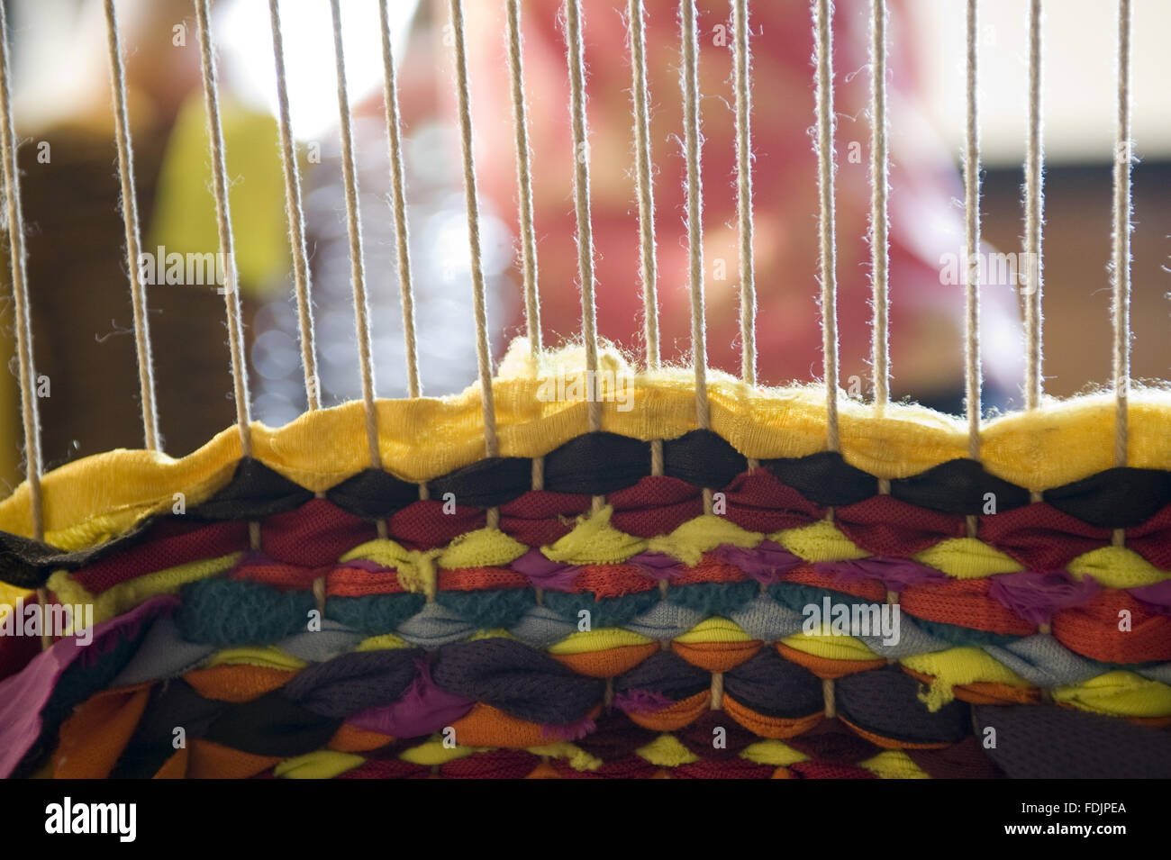 Close view of cotton being woven on a loom at Quarry Bank Mill, Styal, Cheshire. Stock Photo