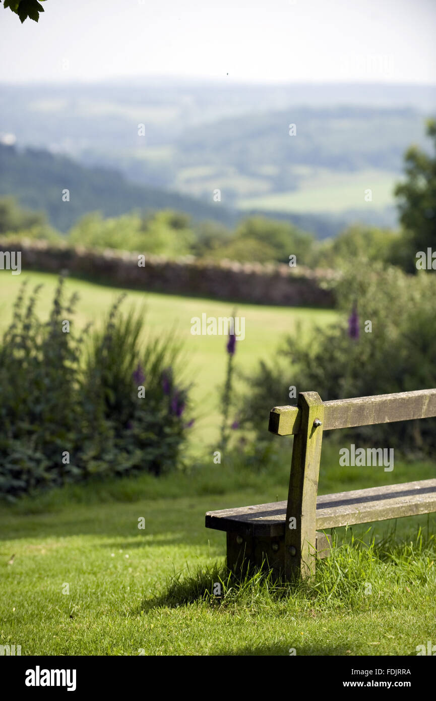 A wooden bench with a beautiful view over the grounds and countryside at The Kymin, Monmouthshire, Wales. Stock Photo