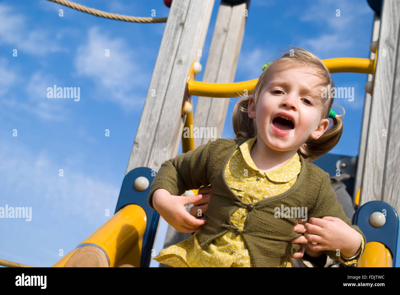Girl on slide in playground Stock Photo - Alamy