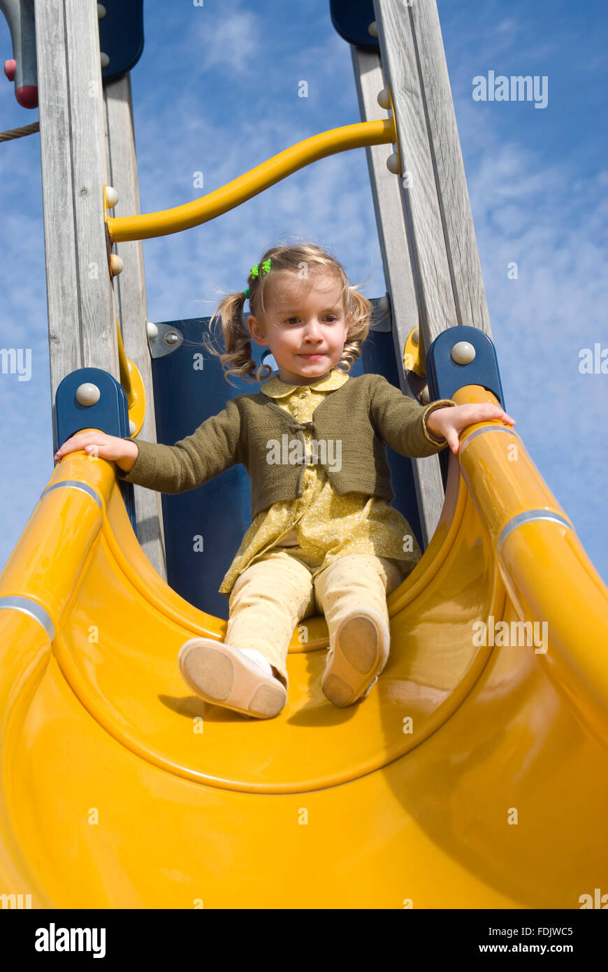 Girl on slide in playground Stock Photo - Alamy