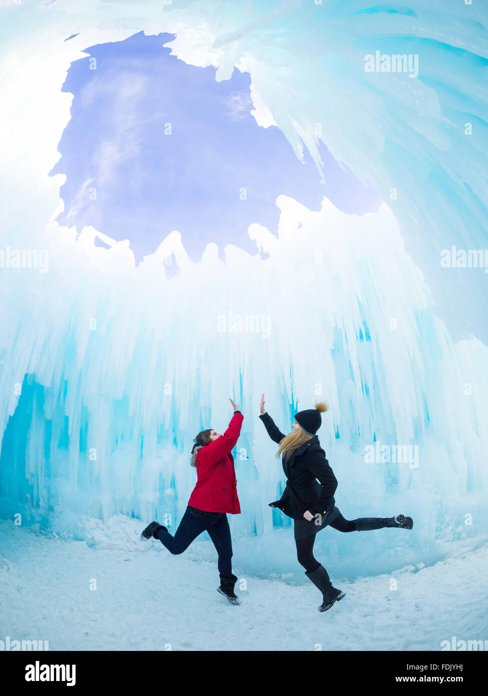 Two friends high five under the Dome Room of the 2015-16 Ice Castle at Hawrelak Park in Edmonton, Alberta, Canada. Stock Photo
