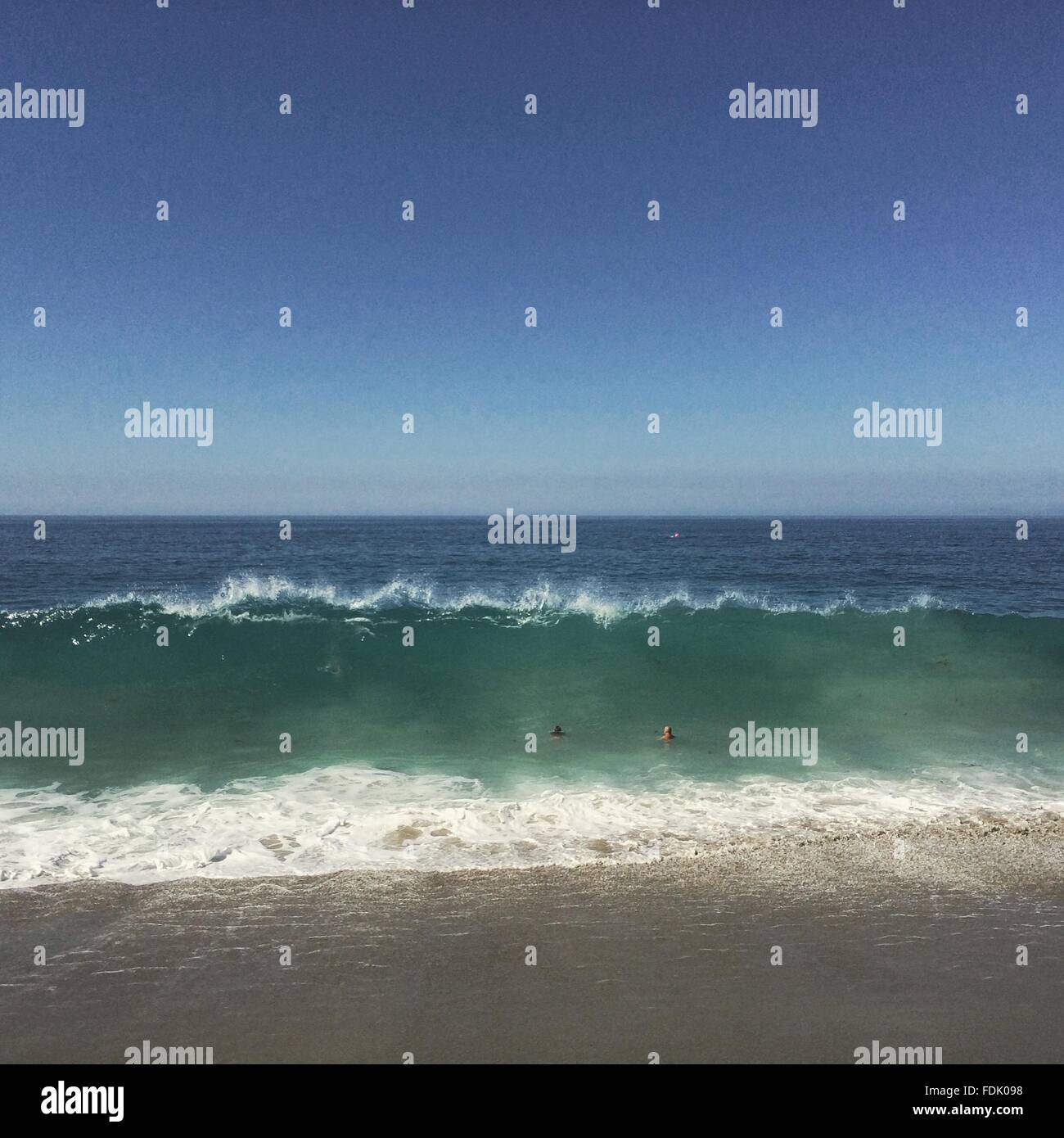 Father and son swimming in ocean Stock Photo