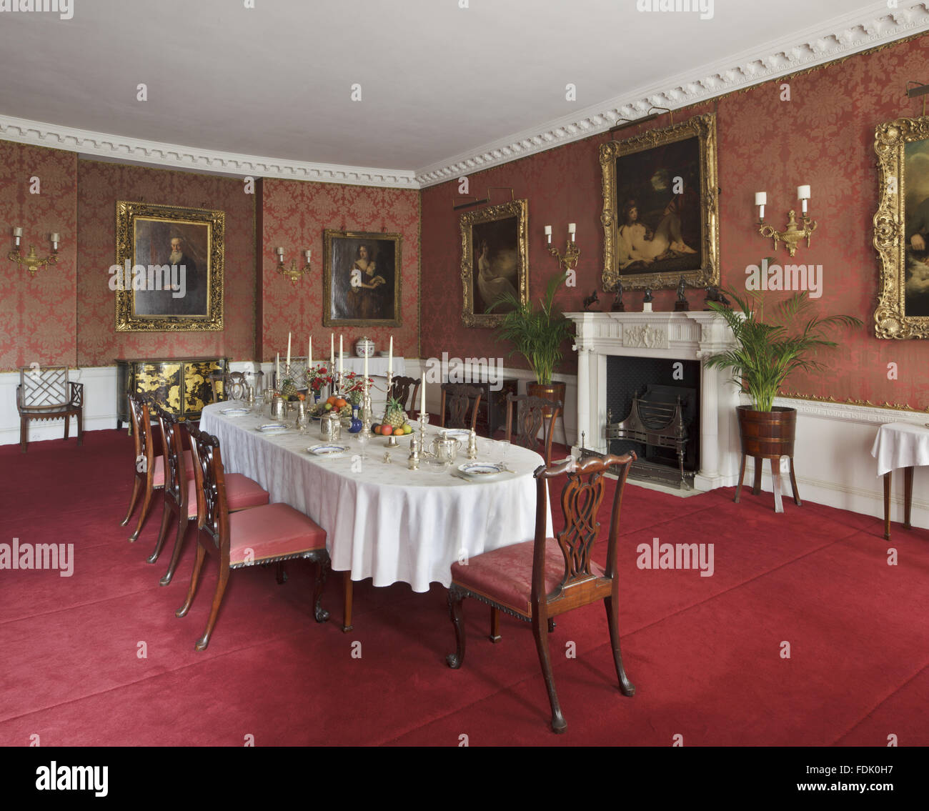 The Dining Room at Polesden Lacey, Surrey. The Dining Room was designed by Poynter in 1903-5 but the mahogany dining table of c.1800 is not original to the room. The set of eight mahogany dining-chairs are late 19th-century, in the style of Thomas Chippen Stock Photo