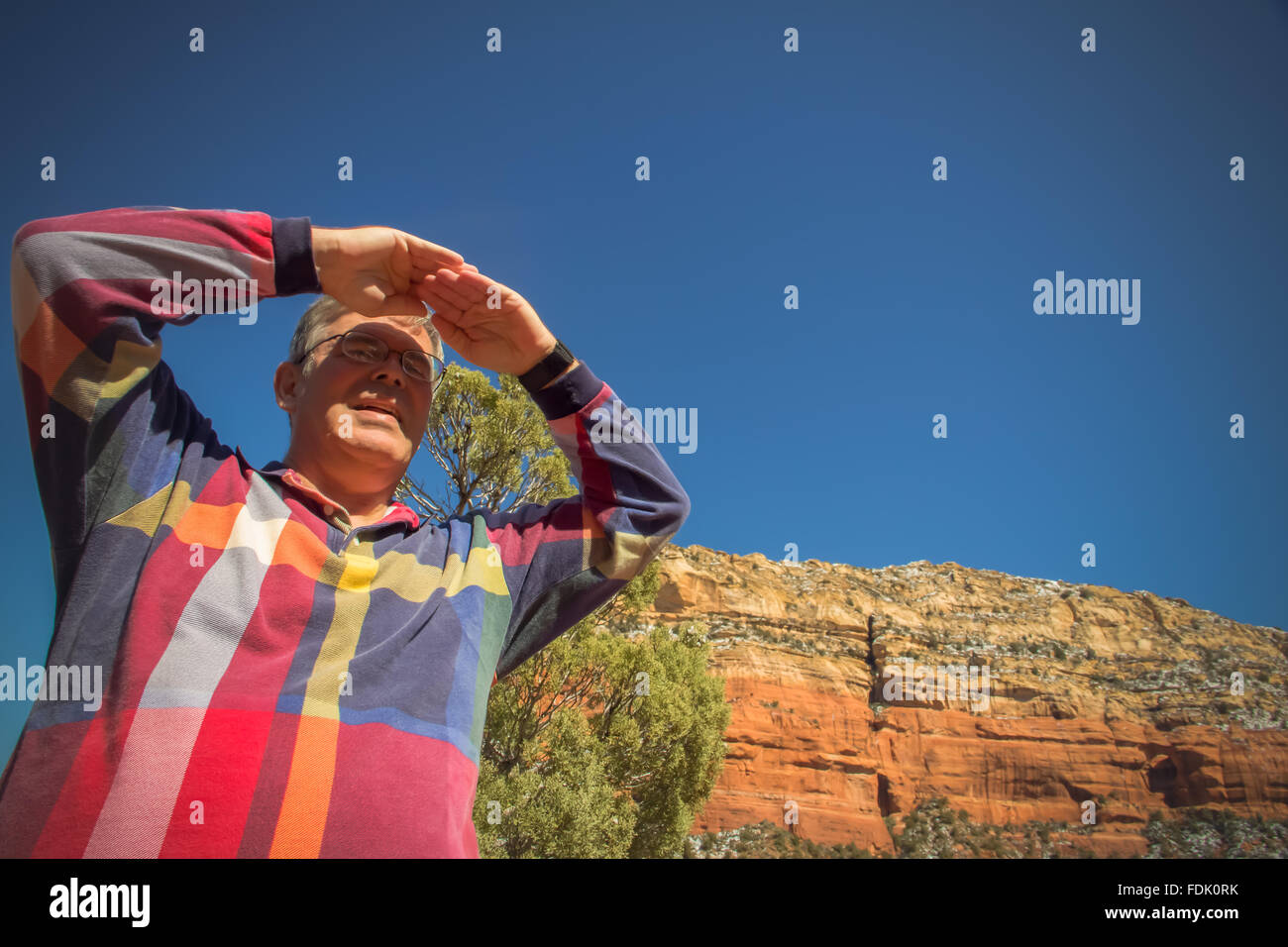 Man shielding eyes looking at view, Sedona, Arizona, United States Stock Photo