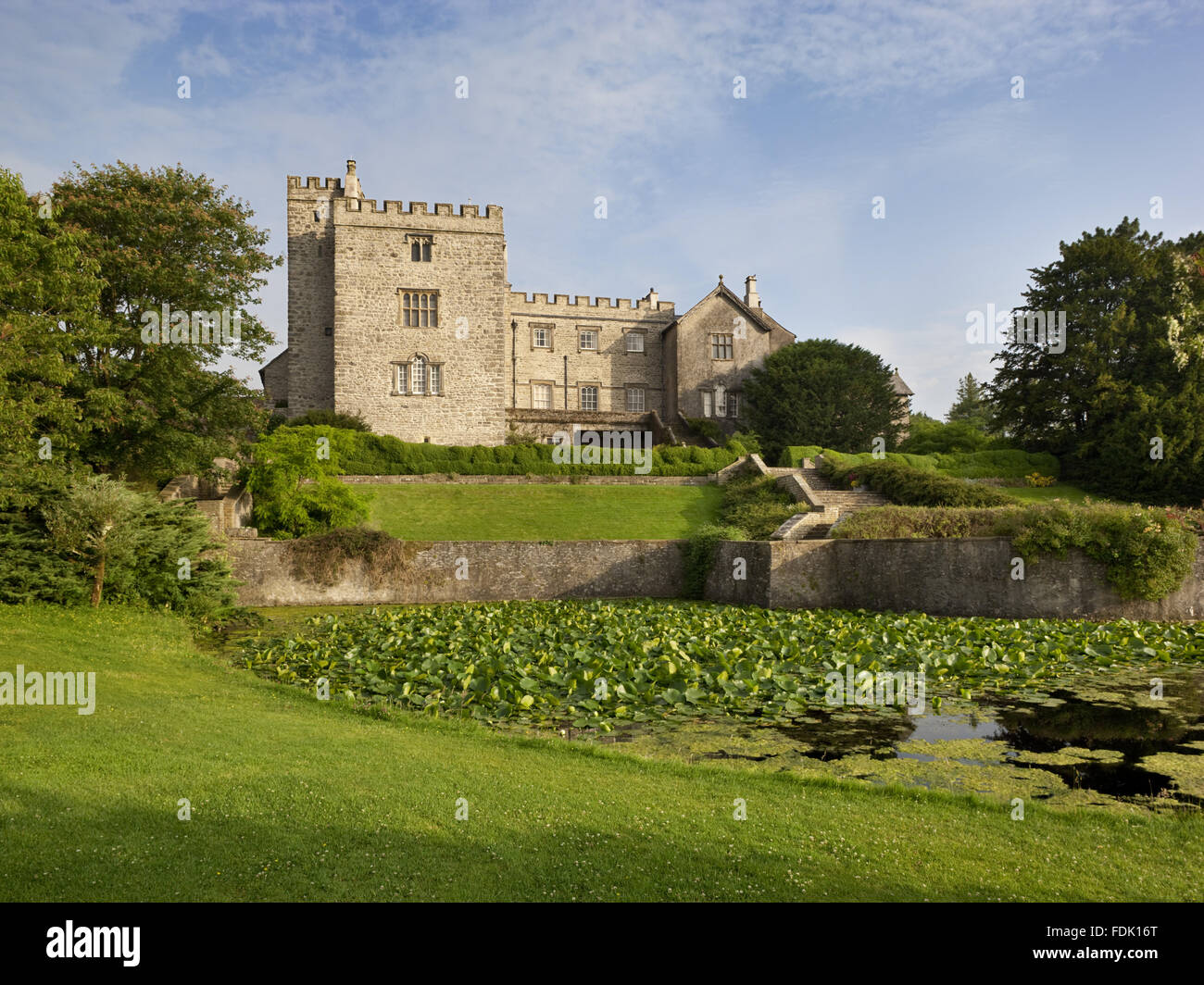 A view across the lake and garden to the south east front of Sizergh Castle, near Kendal, Cumbria. The lake may have been formed out of part of the original solar tower moat in the seventeenth century. Stock Photo