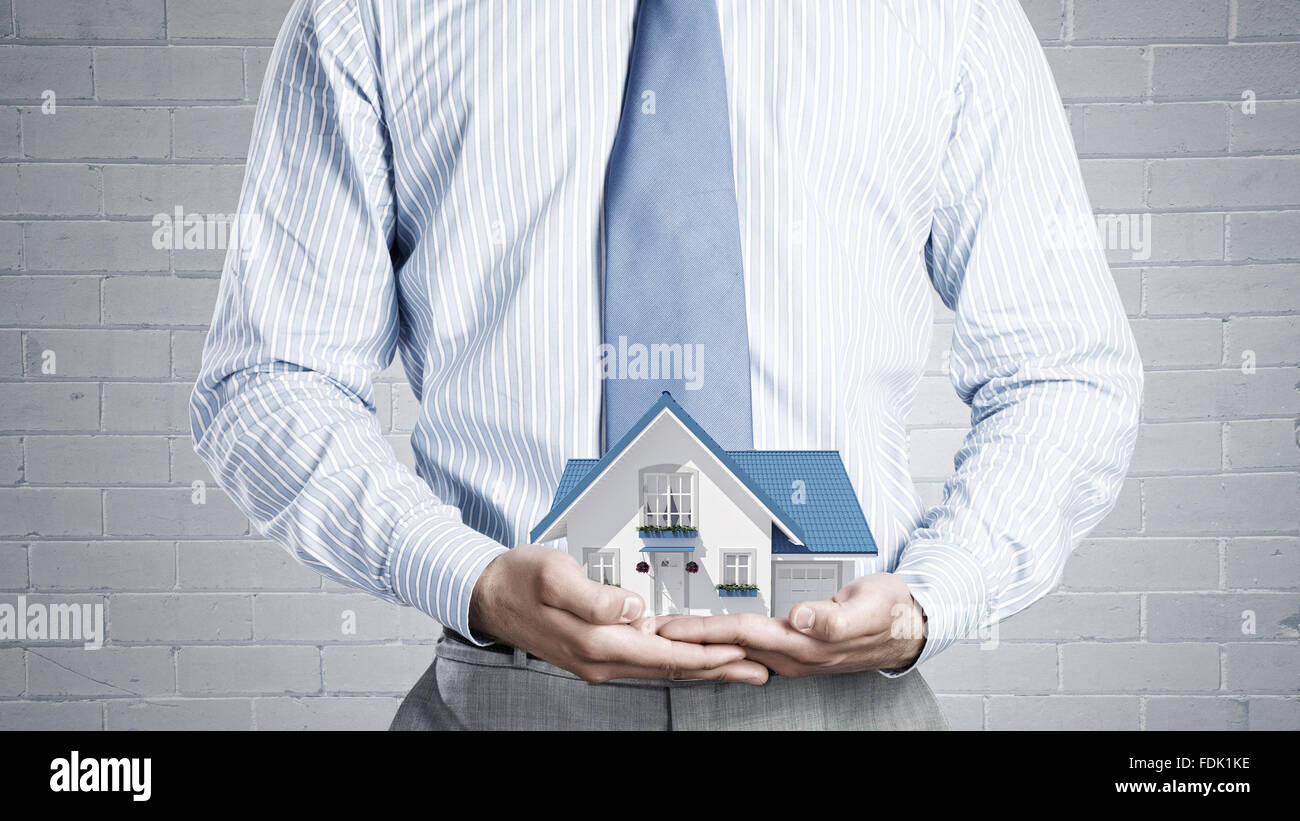 Close up of businessman holding house model in hands Stock Photo - Alamy