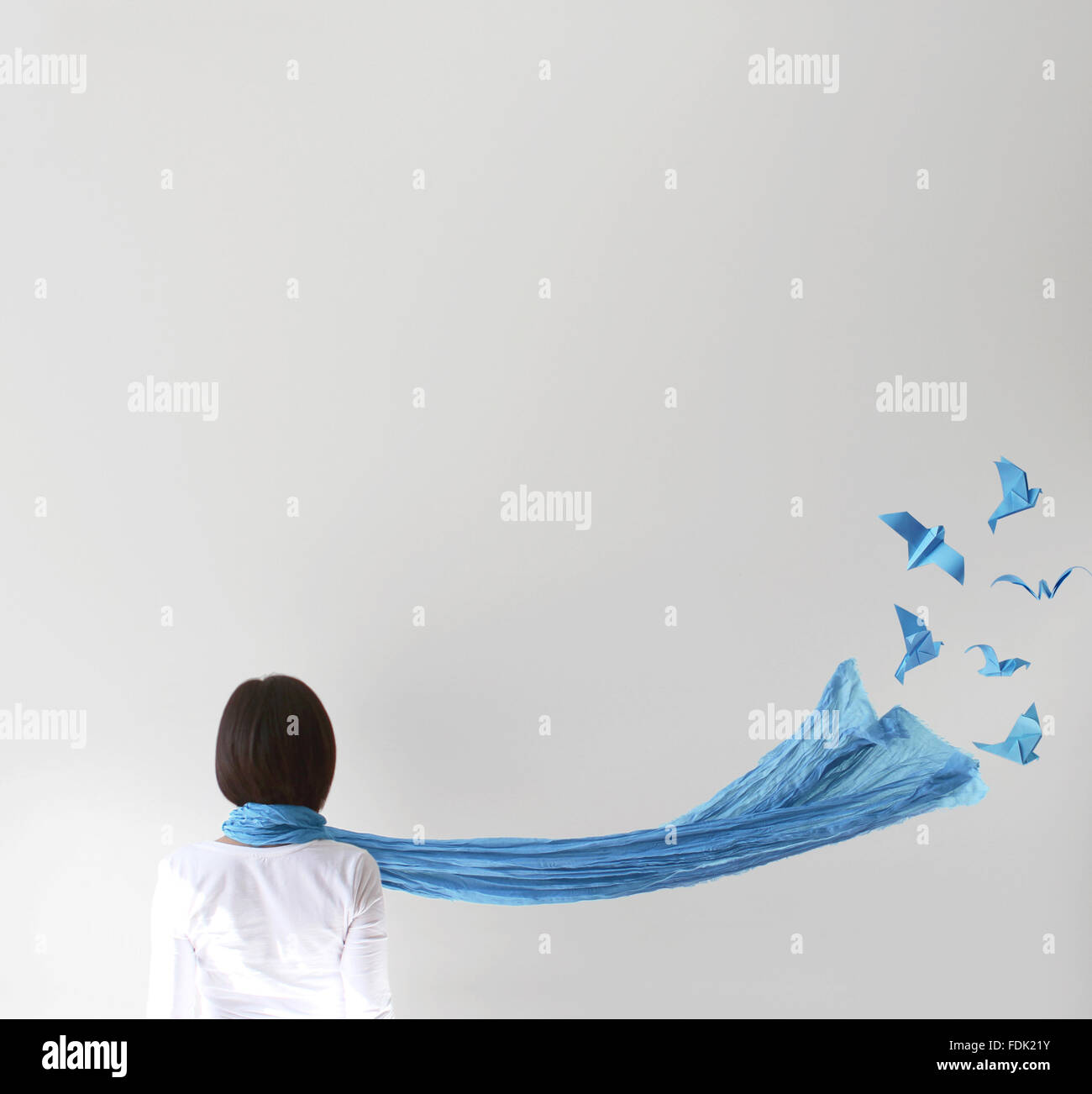 Rear view of woman with blue scarf and origami birds Stock Photo