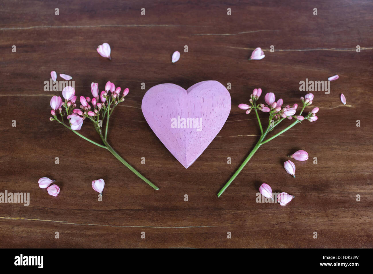 Pink wooden heart and flowers on a table Stock Photo