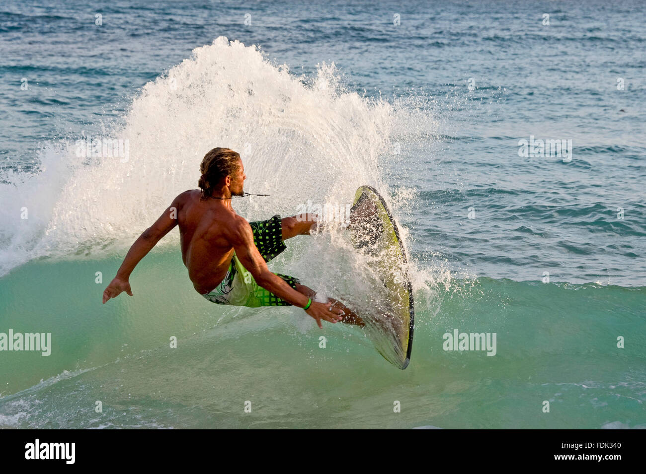 A skimboarder performs a trick on the beach at Santa Maria, Island of Sal, Cape Verde Islands. Stock Photo