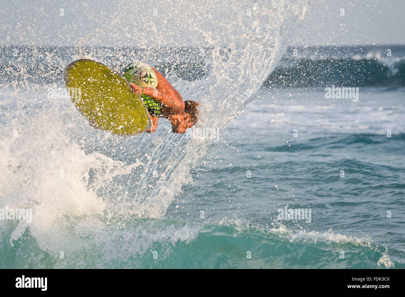 A skimboarder performs a trick on the beach at Santa Maria, Island of Sal, Cape Verde Islands. Stock Photo