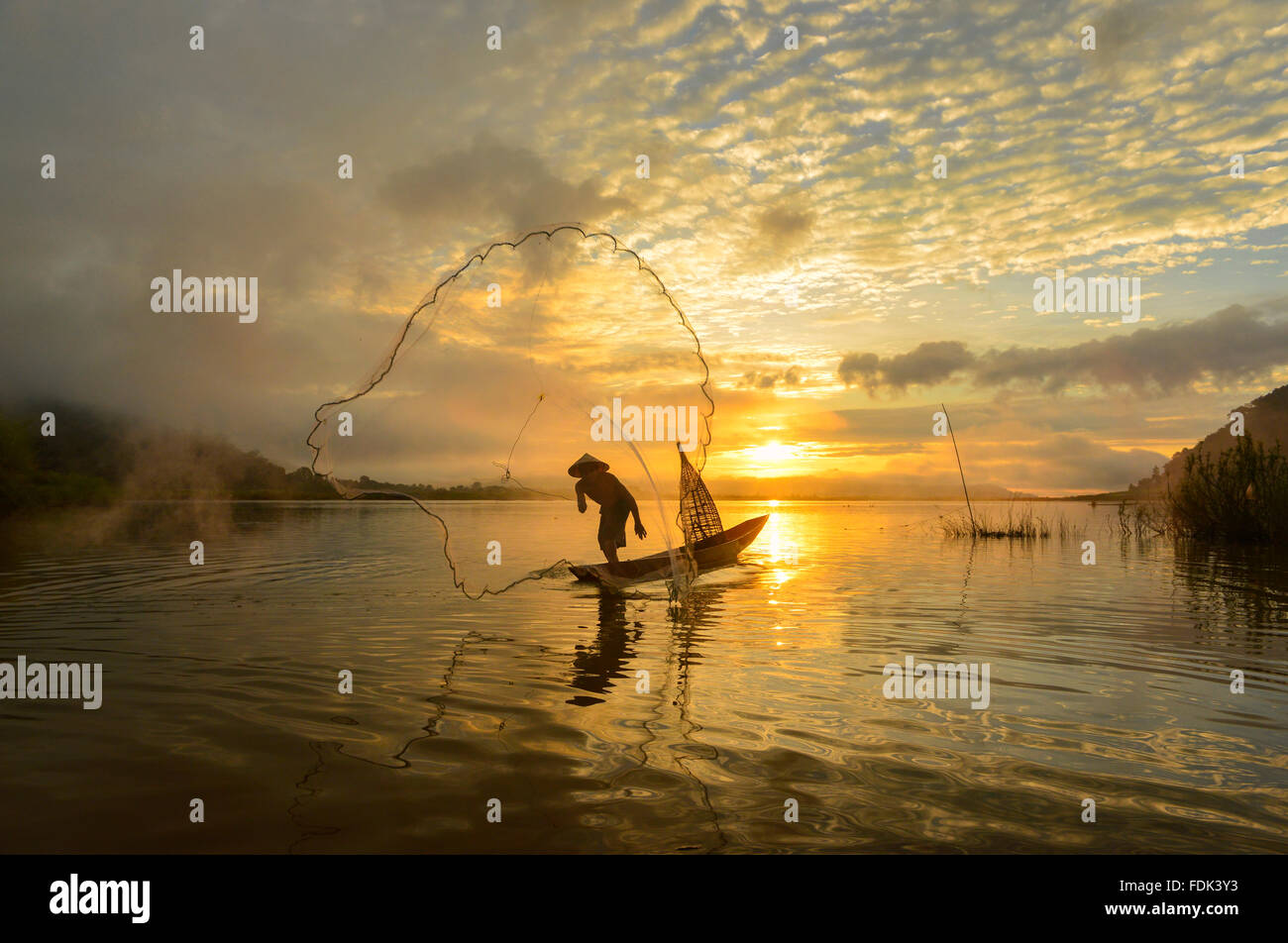 Silhouette of a man throwing fishing net, Mekong river, Sangkhom, Thailand Stock Photo