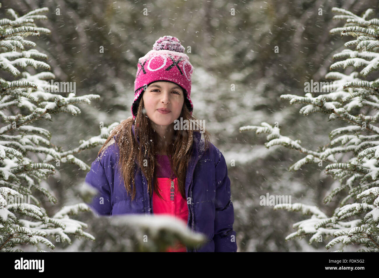 Smiling girl standing in the forest in the snow Stock Photo