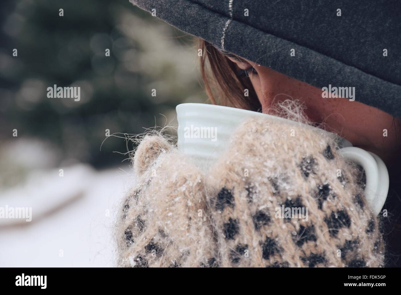 Girl standing outdoors in the snow drinking tea Stock Photo
