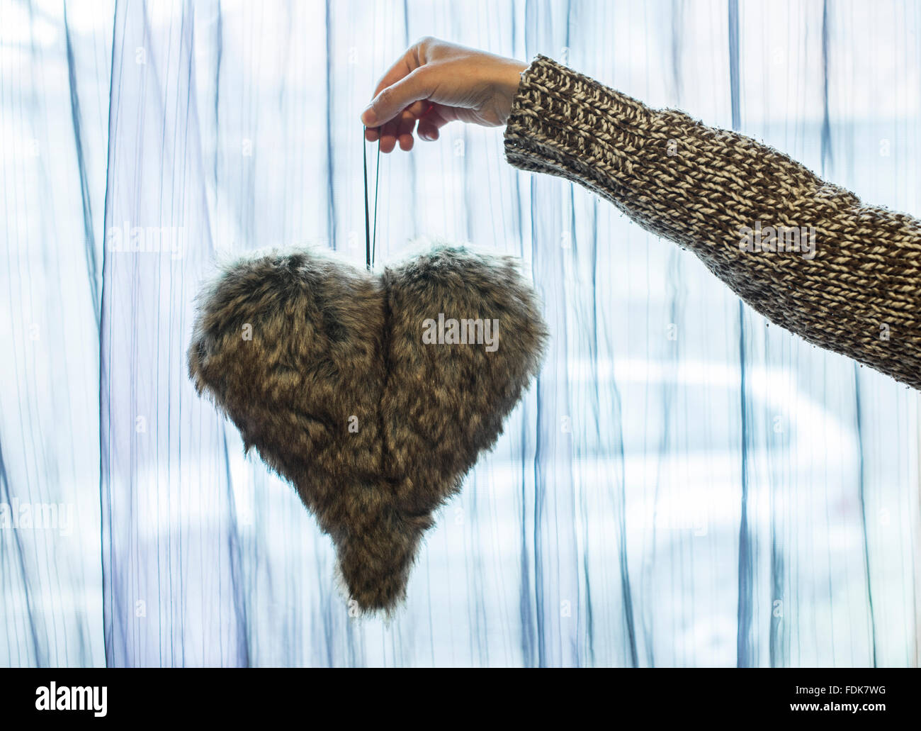 Hand holding furry heart decoration Stock Photo
