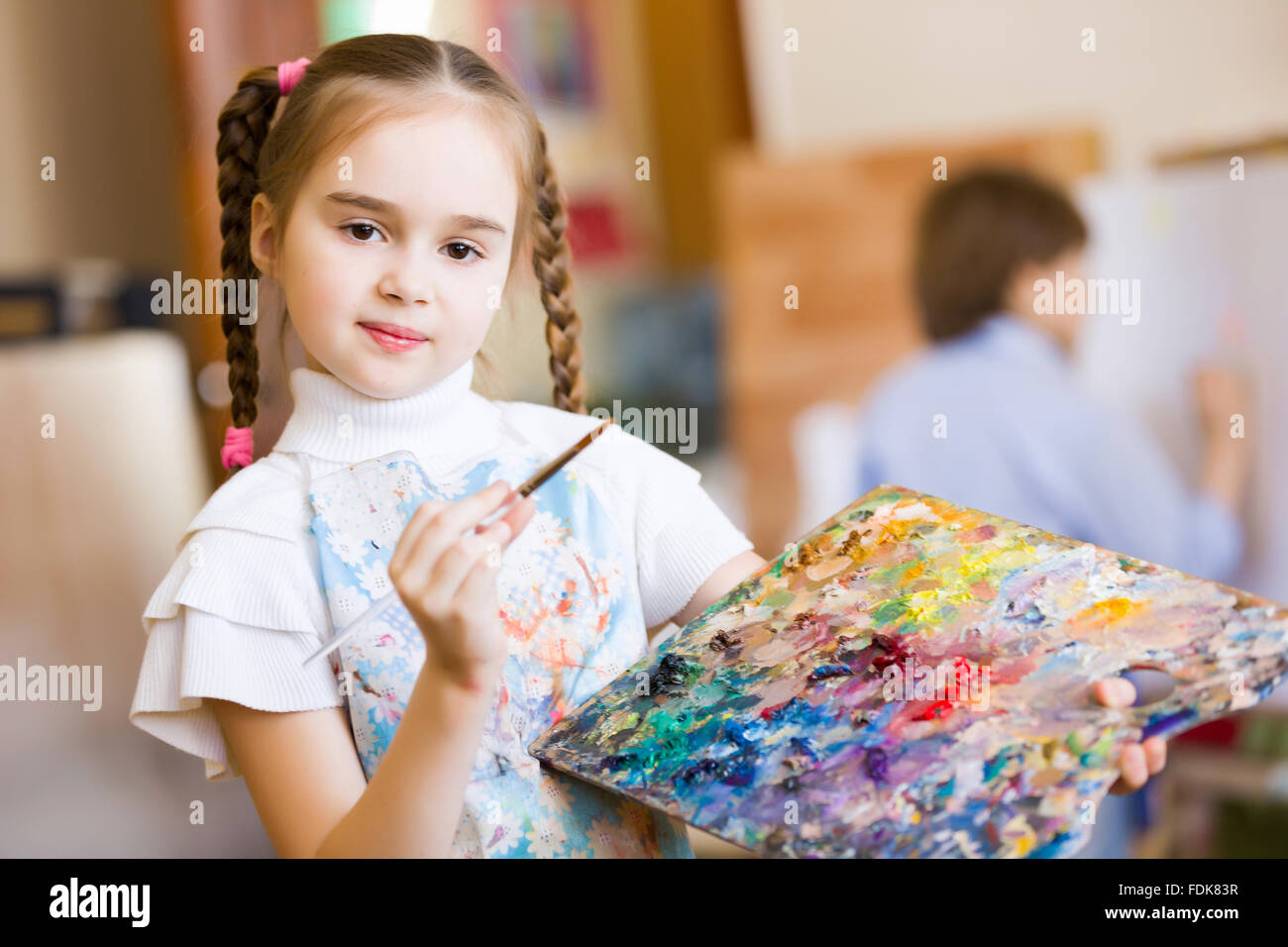 Little cute girl with paint brush and easel Stock Photo - Alamy