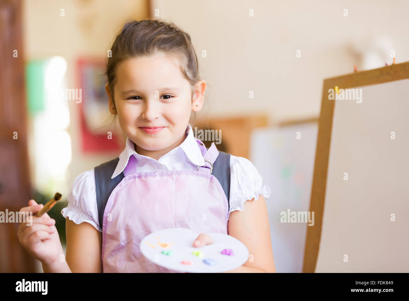 Little cute girl with paint brush and easel Stock Photo - Alamy