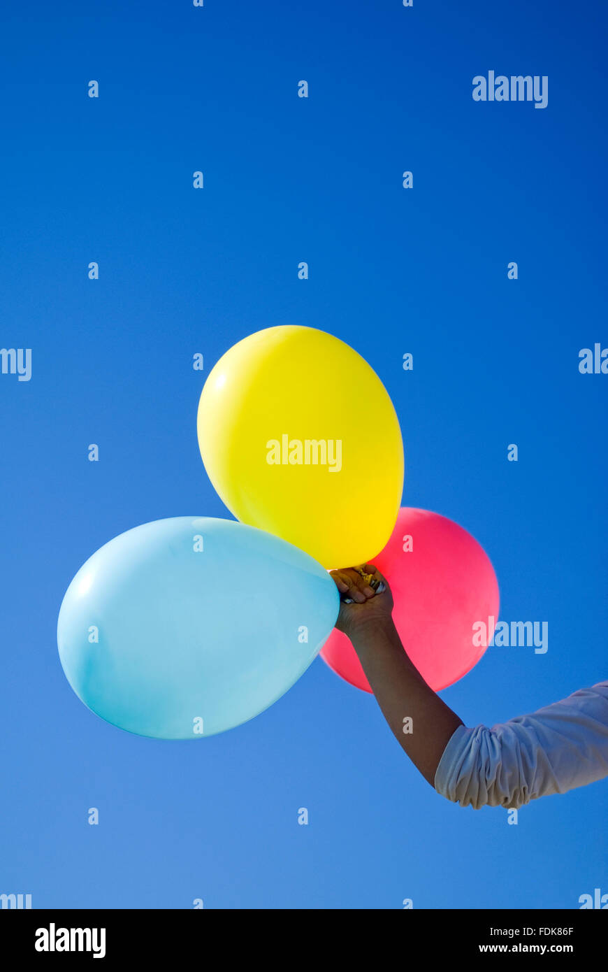 Hand holding multicolored balloons hi-res stock photography and images ...