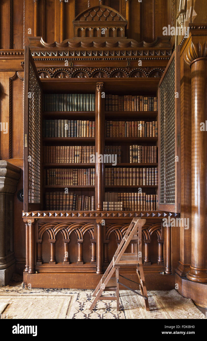 Detail of neo-Norman bookcase designed by Thomas Hopper, with the gilt brass grilles open, in the Library at Penrhyn Castle, Gwynedd. Stock Photo