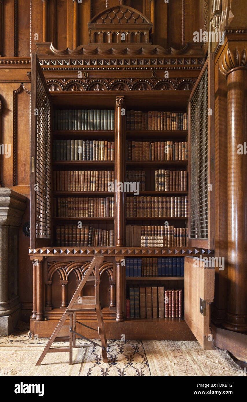 Detail of neo-Norman bookcase designed by Thomas Hopper, with the gilt brass grilles open, in the Library at Penrhyn Castle, Gwynedd. Stock Photo