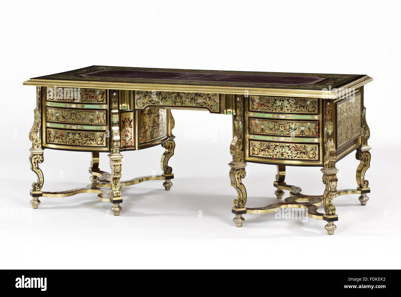 Louis XIV writing table for many years believed to be by Andre Charles Boulle (1642-1732). On a carcass of beech wood, this table is veneered in brass and tortoise shell, the brass veneers being inlaid with elaborate polychrome marquetry patterns in mothe Stock Photo