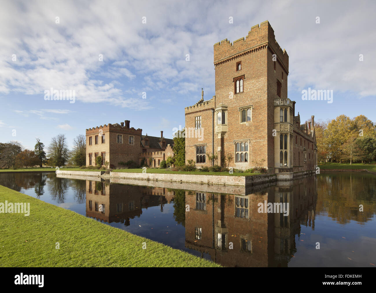 View over the moat of the south range of Oxburgh Hall, Norfolk. Sir Edmund Bedingfeld built Oxburgh Hall in about 1482, but the Great Hall on the south side was demolished in 1775. The battlemented passageway filling the space was added in 1863. Stock Photo
