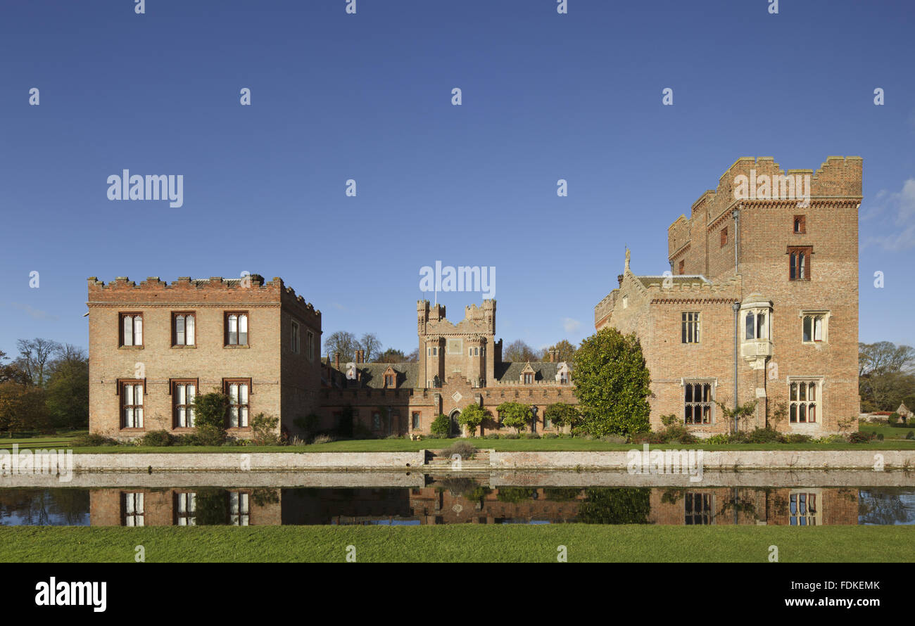 View over the moat of the south range of Oxburgh Hall, Norfolk. Sir Edmund Bedingfeld built Oxburgh Hall in about 1482, but the Great Hall on the south side was demolished in 1775. The battlemented passageway filling the space was added in 1863. Stock Photo