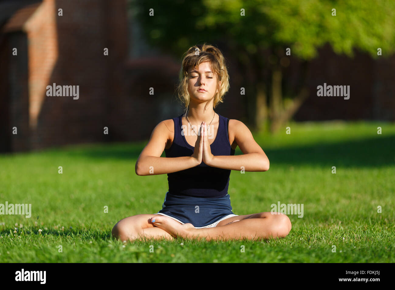 Pretty young girl doing yoga exercises in the park Stock Photo - Alamy