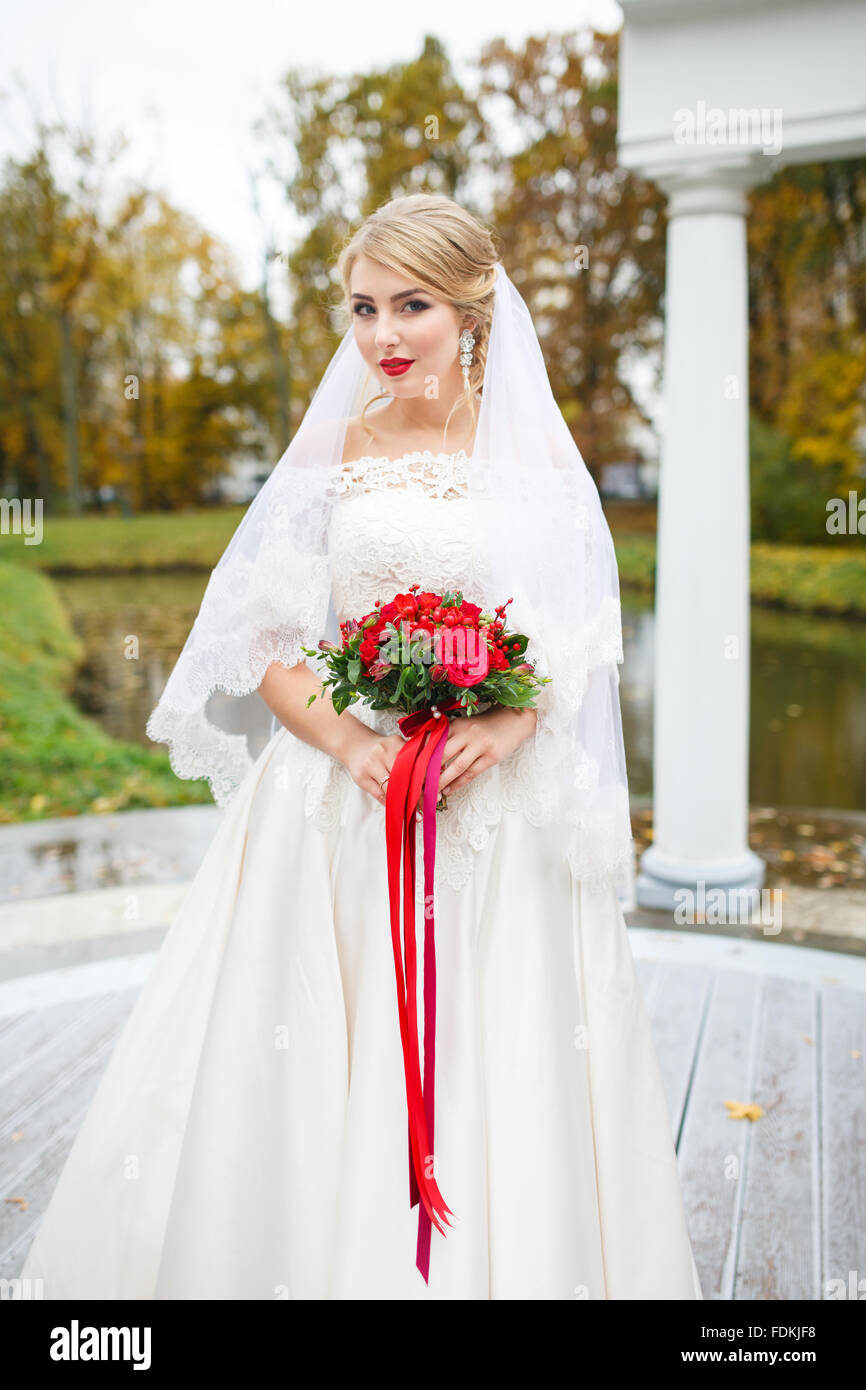 The bride with a bouquet in the fall Stock Photo - Alamy
