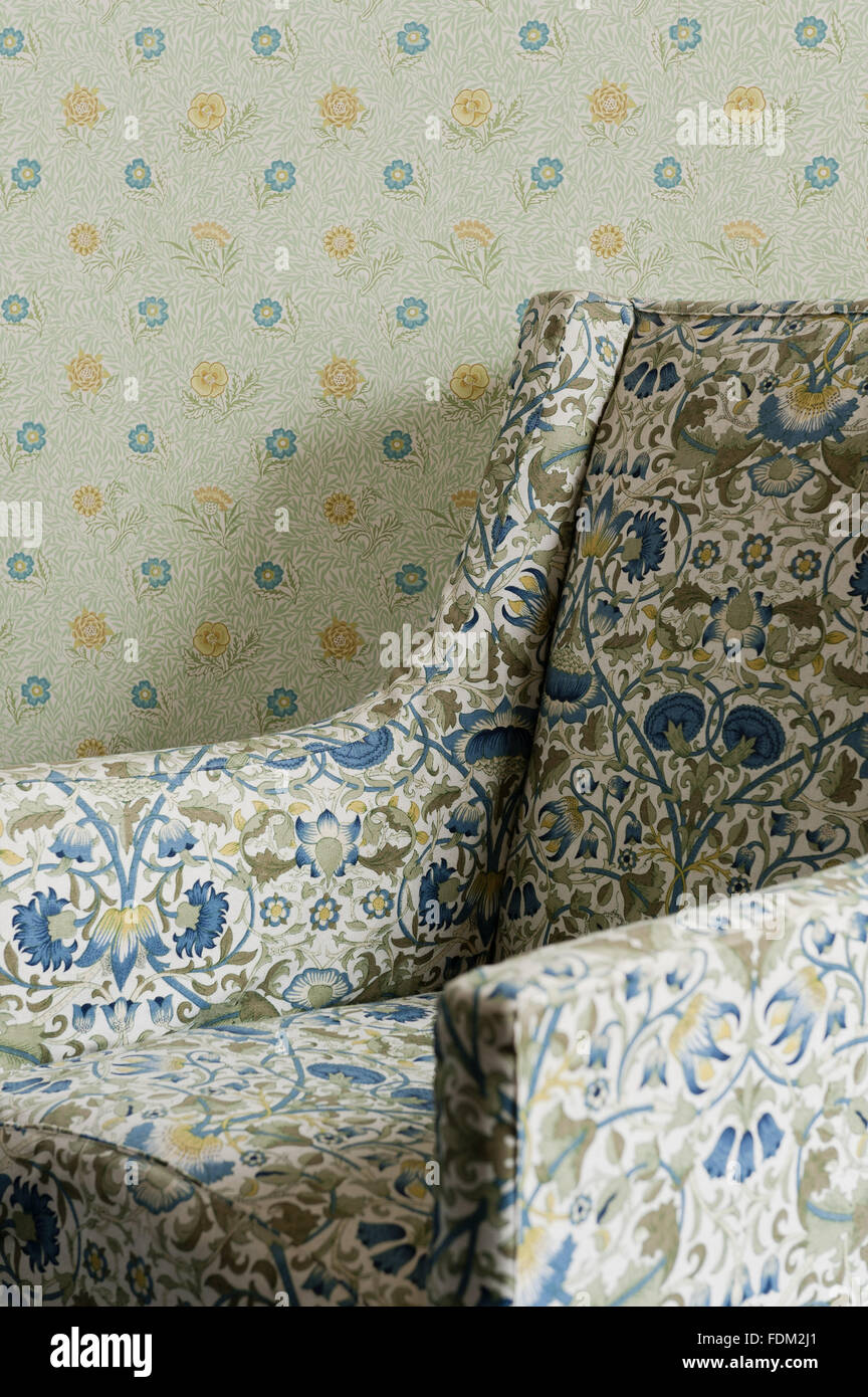 Upholstered easy chair, with loose linen cover in a reprint of William Morris 'Lodden' chintz,  in the North Dressing Room at Standen, West Sussex. Stock Photo