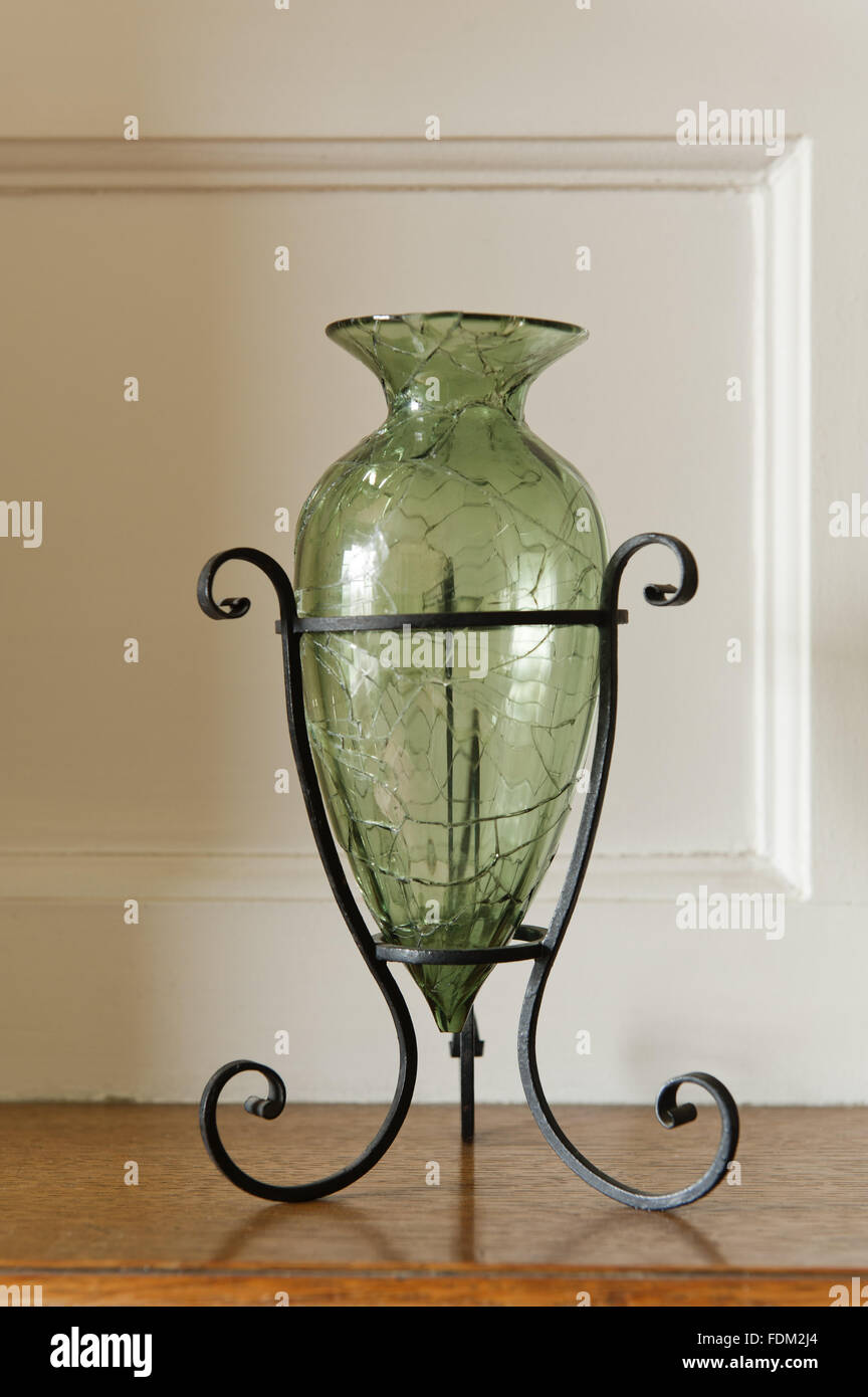 Green tinted glass vase, one of a pair, in the Larkspur Dressing Room at  Standen, West Sussex. The vase was made by James Powell & Son, London, and  is held in a