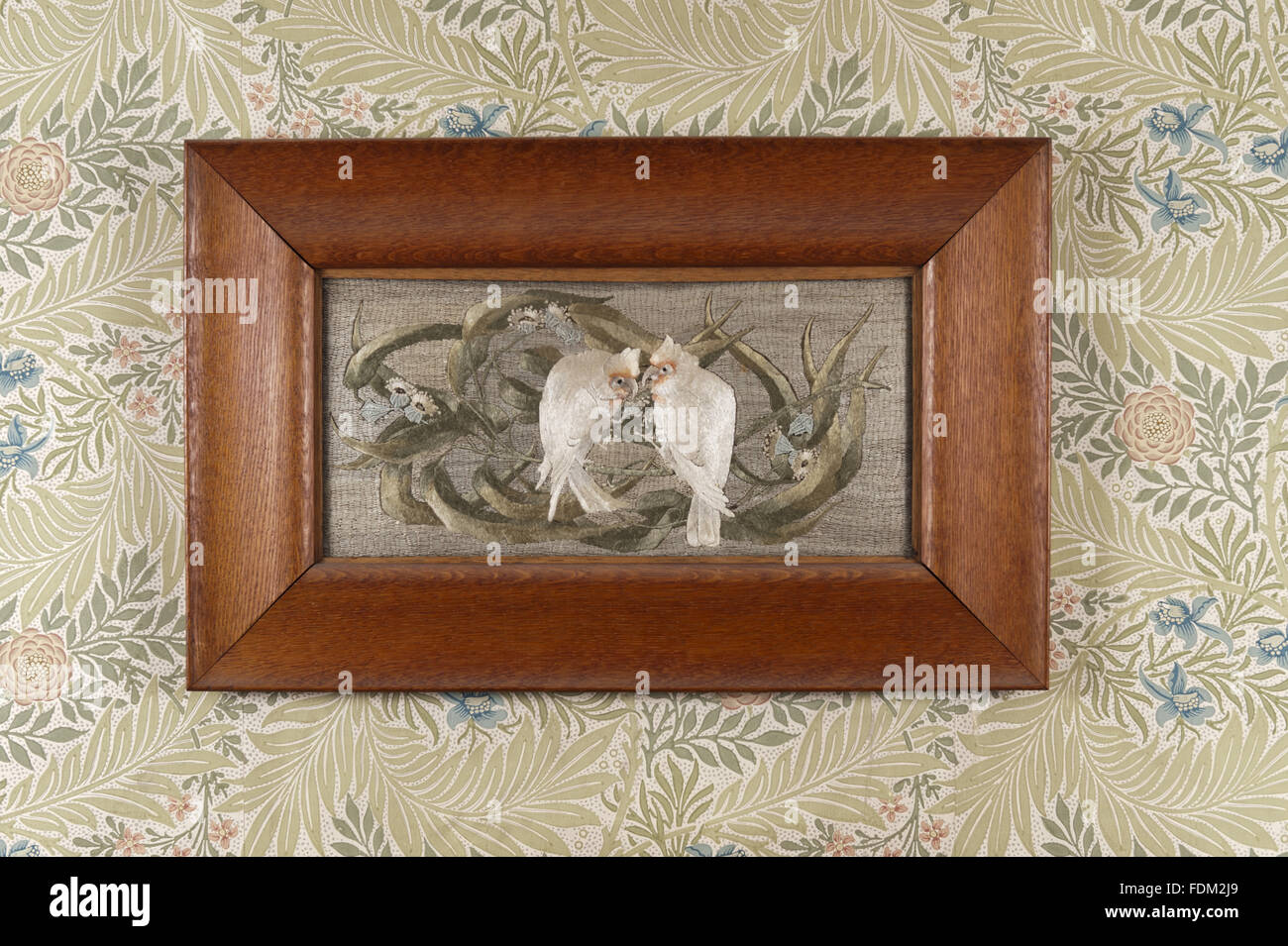 Framed silk embroidered picture in the Larkspur Bedroom at Standen, West Sussex. The design of two white birds and flowers is in the manner of Henry Stacey Marks, the embroidery was executed by Mrs Margaret Beale (1847-1936) and her three daughters. NT in Stock Photo