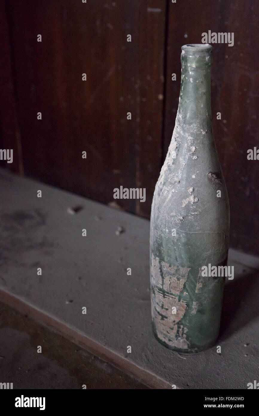 An old bottle sitting on a dusty shelf at Dyffryn House, Vale of