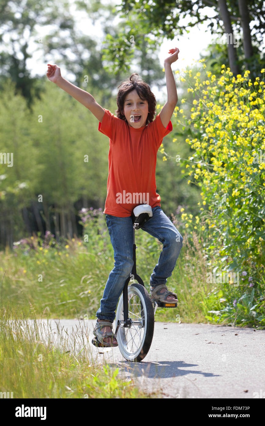 Boy balancing on a unicycle in the park Stock Photo